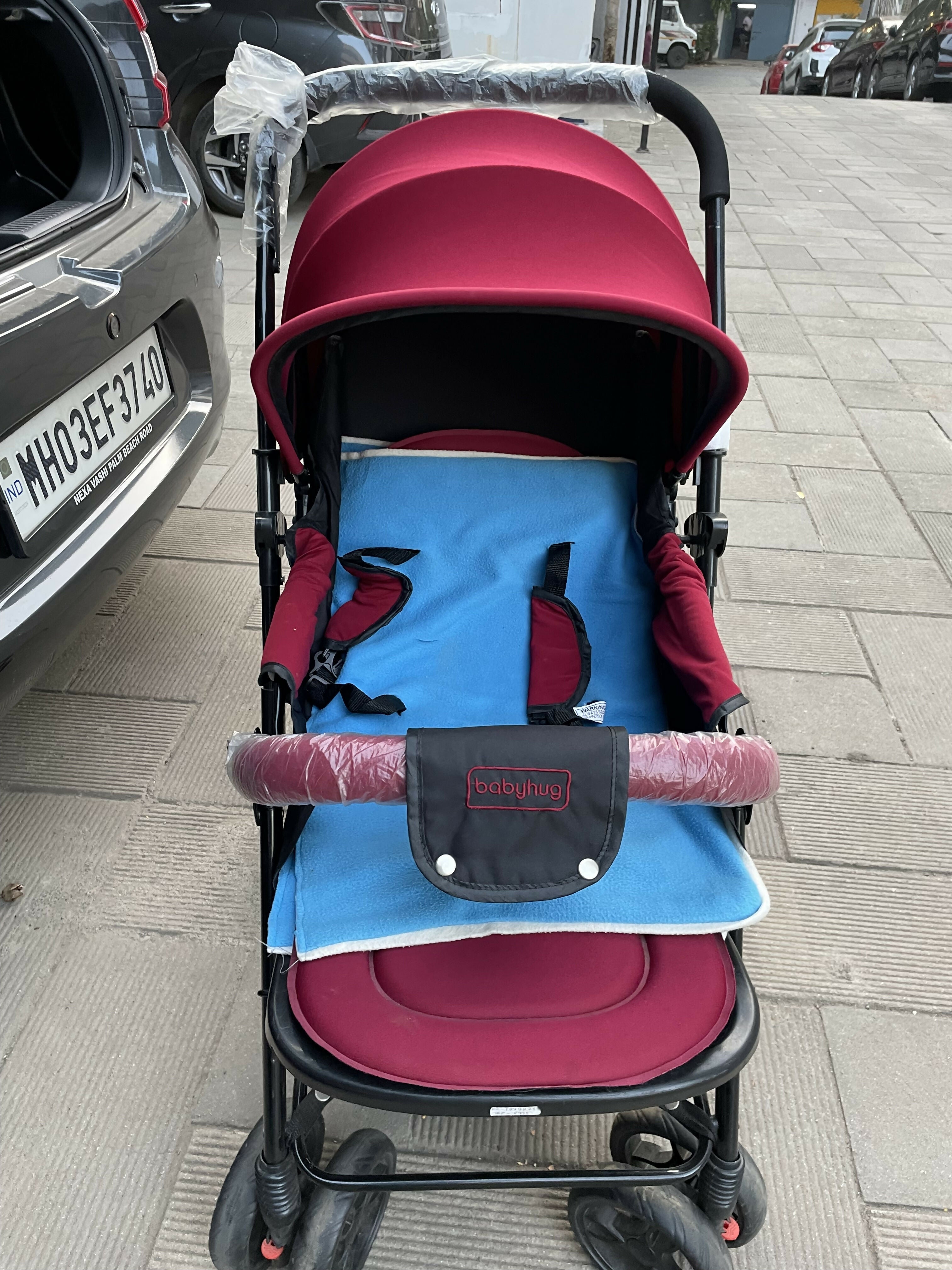 Nearly new red baby stroller with sun canopy, padded seat, lightweight design, and foldable convenience—ideal for on-the-go families!