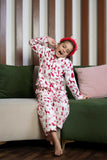  The set includes a long-sleeved top with a collar and matching pants, both adorned with delightful red prints of reindeer, snowflakes, and Christmas trees on a white background. 